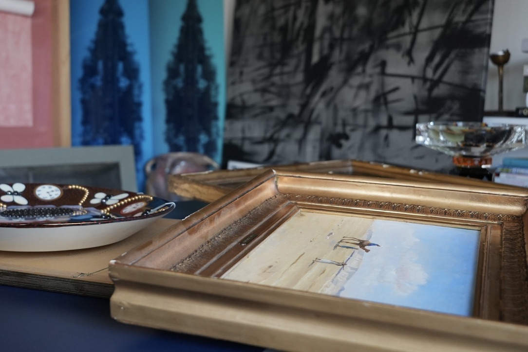 Nærbillede af bord med privat kunstsamling, bl.a. keramisk fad af Birger Kaipiainen og maleri af A. Riis Carstensen.