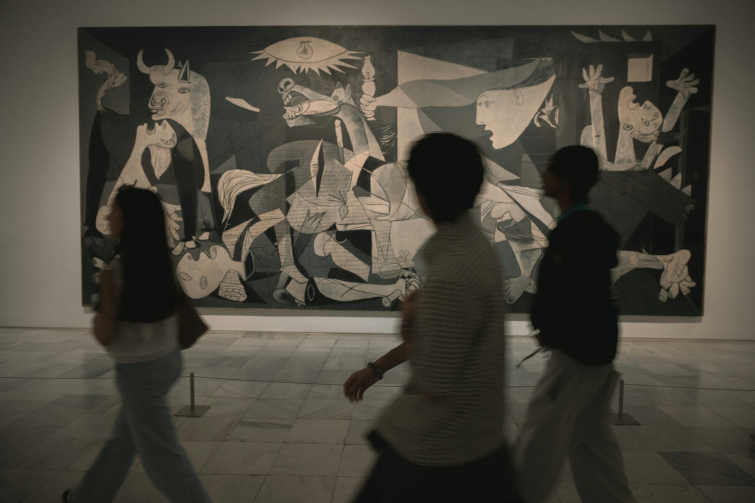 Museumsbesøgende går forbi Pablo Picassos maleri “Guernica”